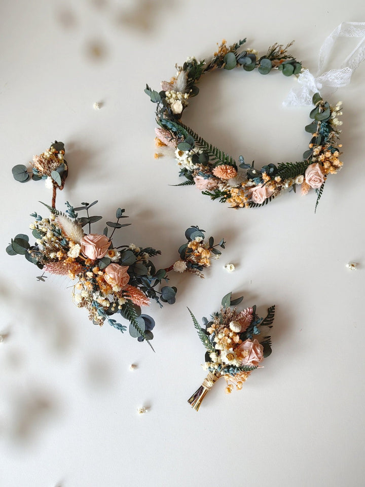 Set of floral bridal crown, hair vine and a boutonniere on a light background