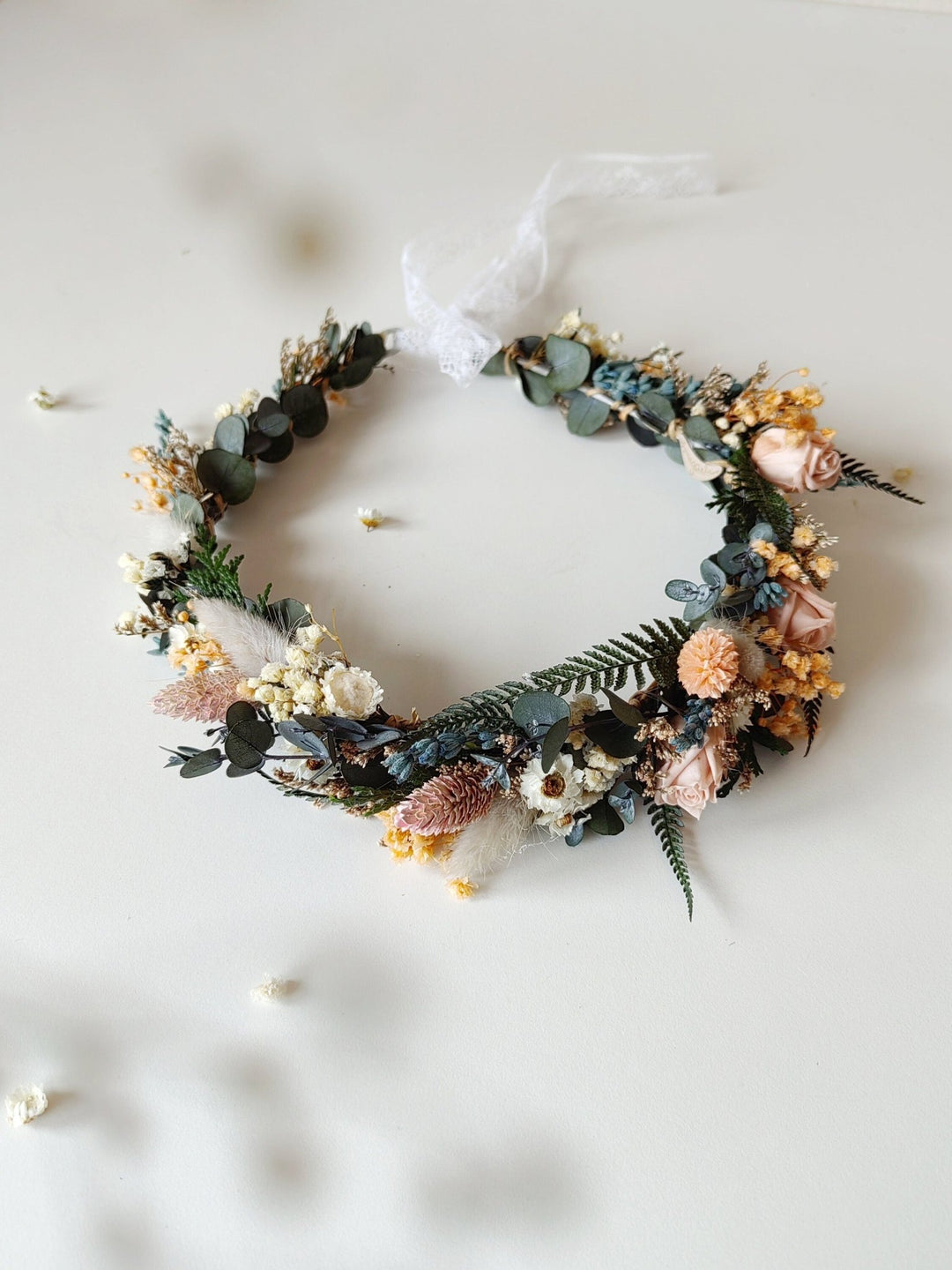 Floral wreath with greenery and pastel flowers on a white background