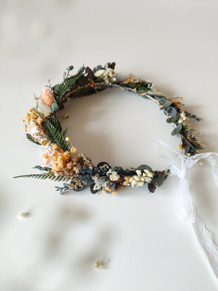 Floral headband with greenery and dried flowers on a white background