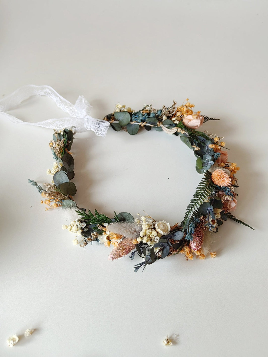 Floral bridal crown with greenery and dried blush flowers on a white background