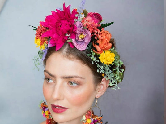Woman wearing a colorful floral headpiece with a gray background