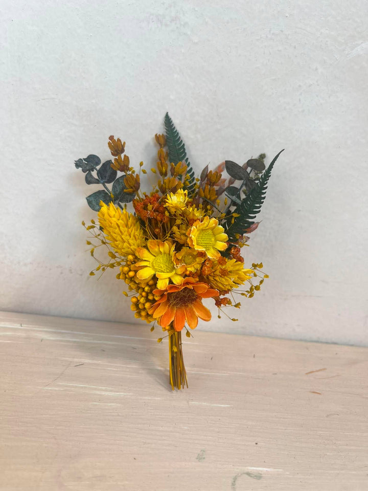 Orangenes und gelbes Knopflochbukett mit Sonnenblume, Gänseblümchen und Farn