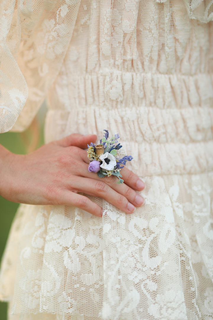 Floral ring on a person wearing a lace dress