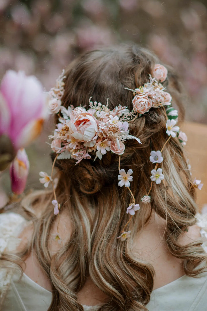 Woman with floral hairpiece and flowers in the background