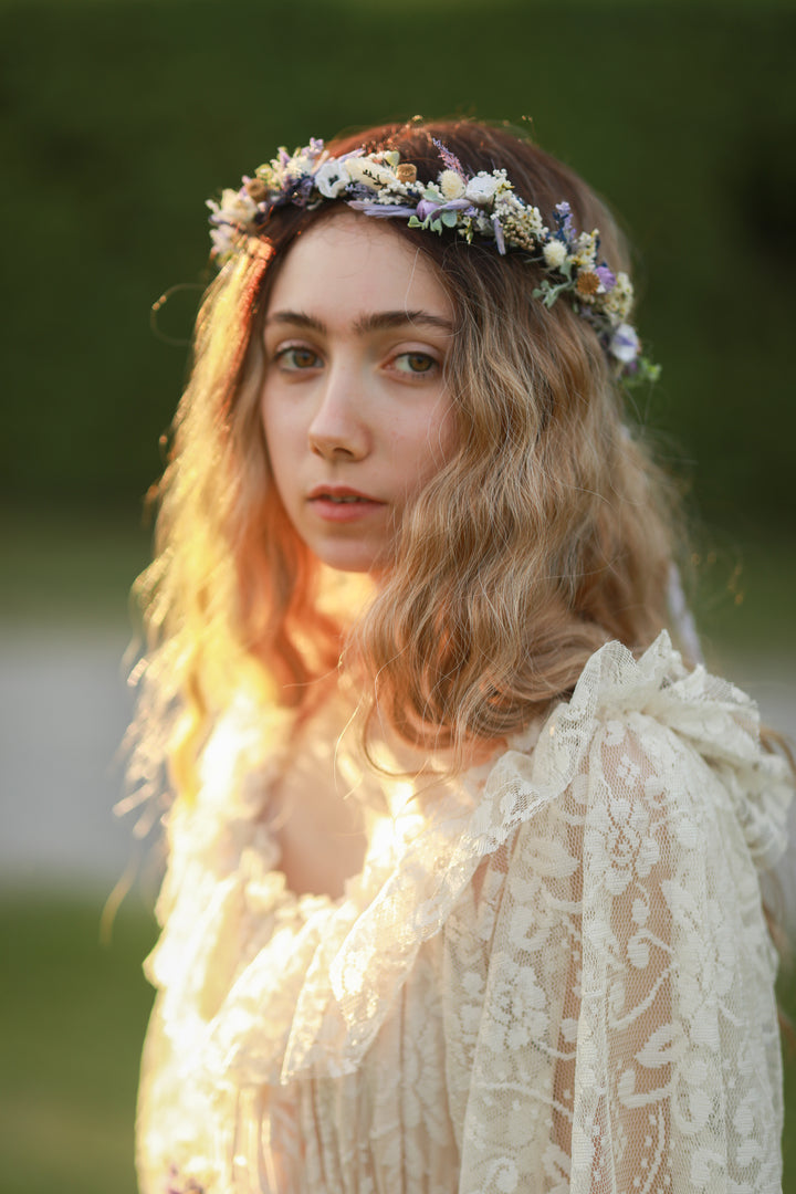 Woman wearing a floral crown and lace dress outdoors