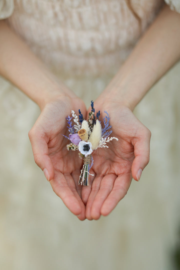 Classic boutonniere for groom  held in hands against a blurred background