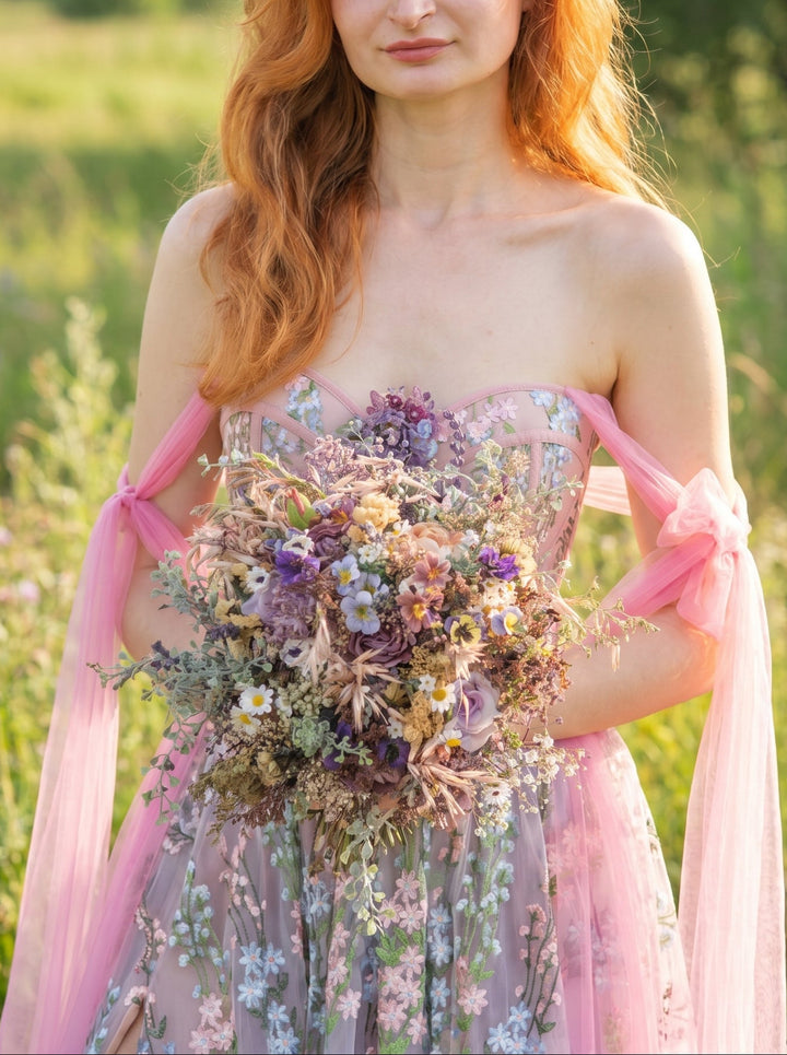 Woman holding a bouquet of flowers in a field