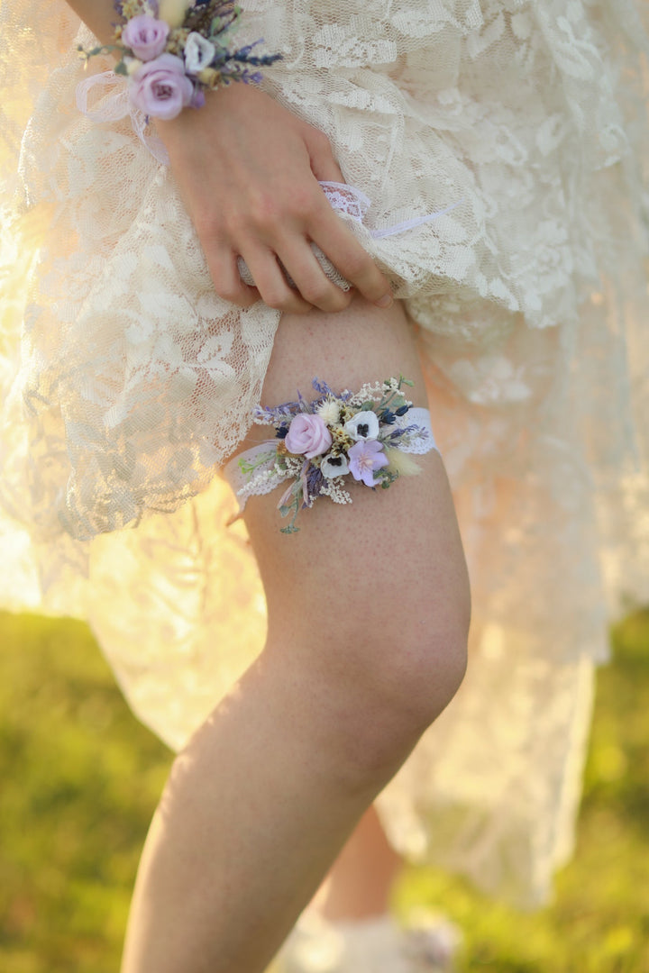 Floral garter on a person's leg with a blurred natural background