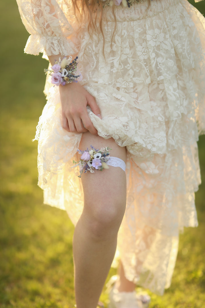 Person wearing a floral garter and lace dress on a grassy background