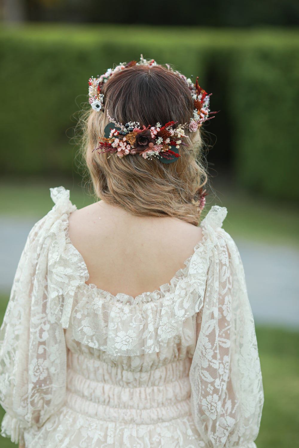 Blush and burgundy bridal hair comb with roses, white anemones, red dried florals and eucalyptus worn in bridal updo, handmade by Magaela