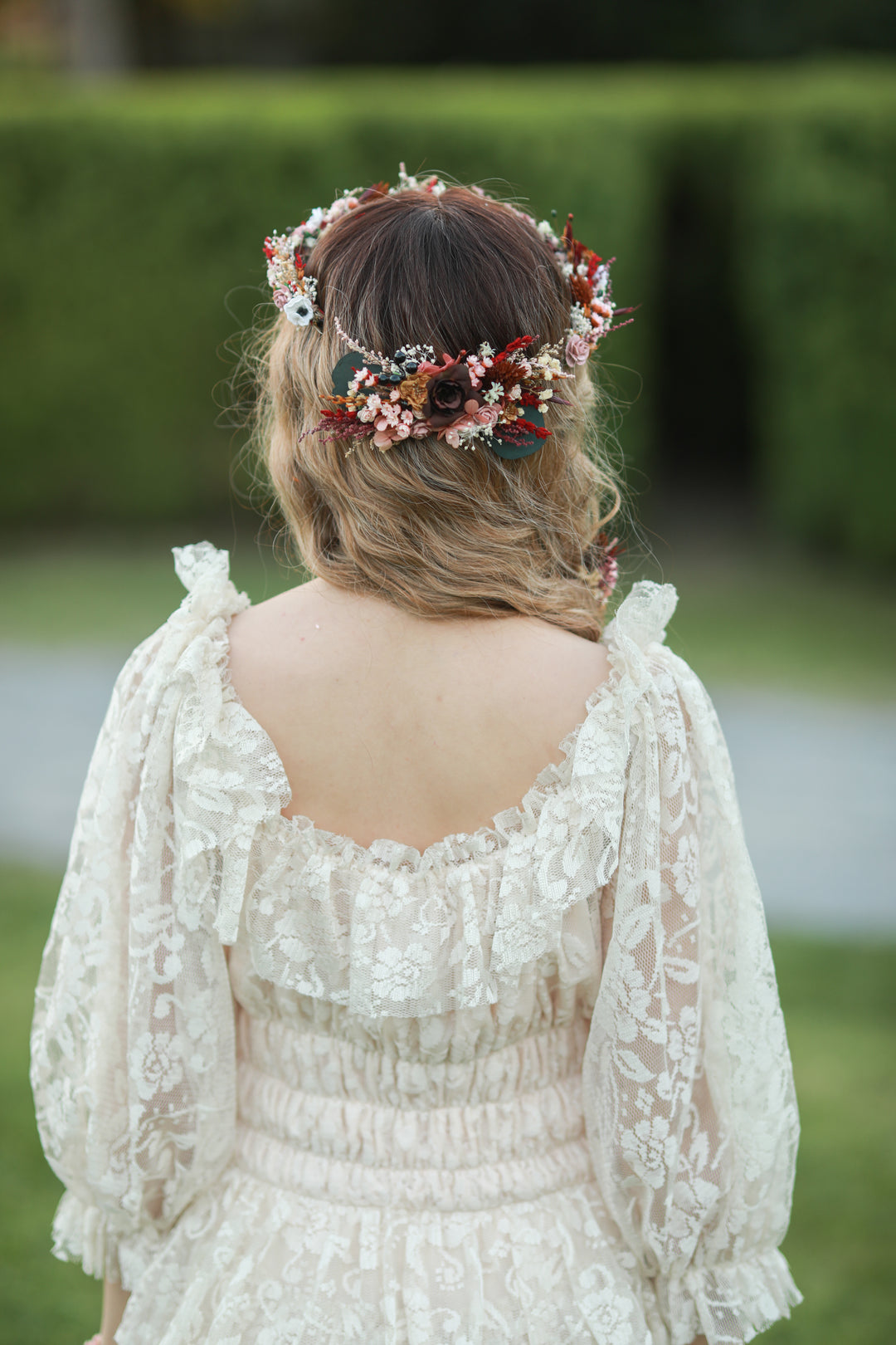 Blush and burgundy bridal hair comb with roses, white anemones, red dried florals and eucalyptus worn in bridal updo, handmade by Magaela