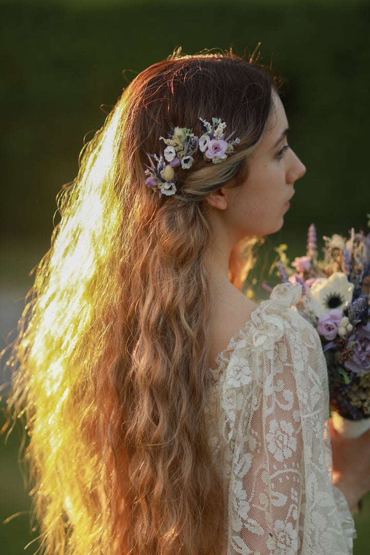 Woman with floral purple hairpins and bouquet in a natural setting