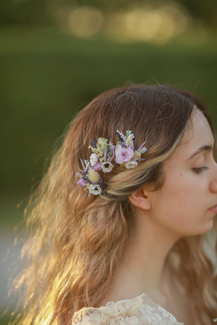 Woman with floral hairpins against a blurred natural background