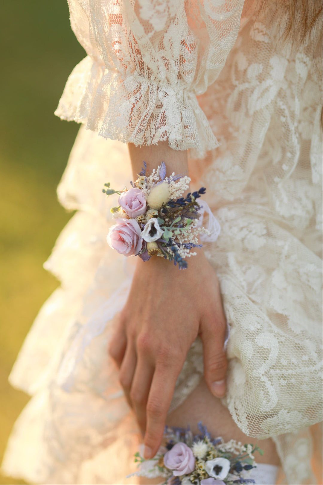 Close-up of a hand wearing a floral wrist corsage with a blurred background