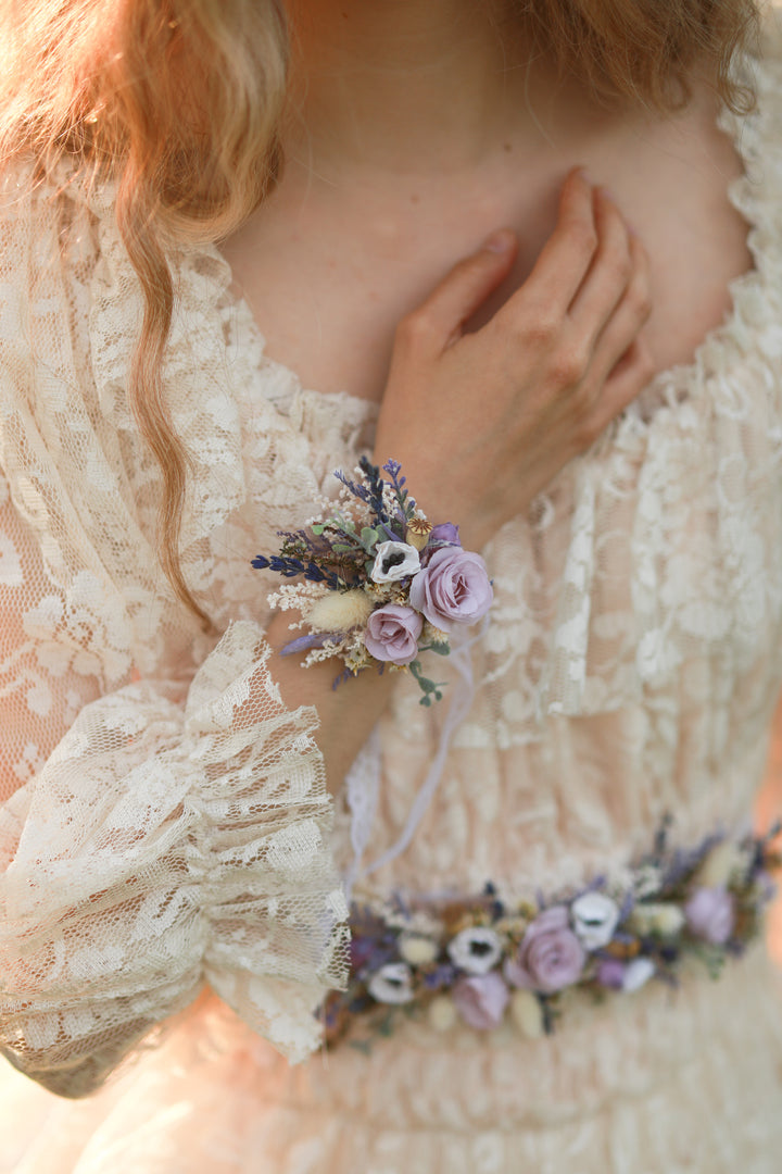 Person wearing a floral wrist corsage with a soft focus background
