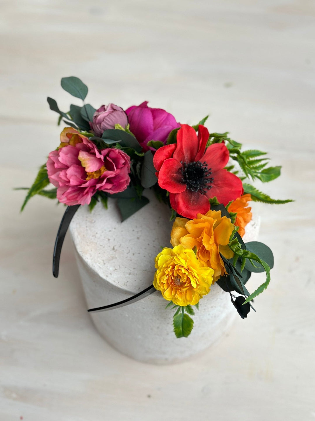 Floral headband with pink, red, and yellow flowers on a white background