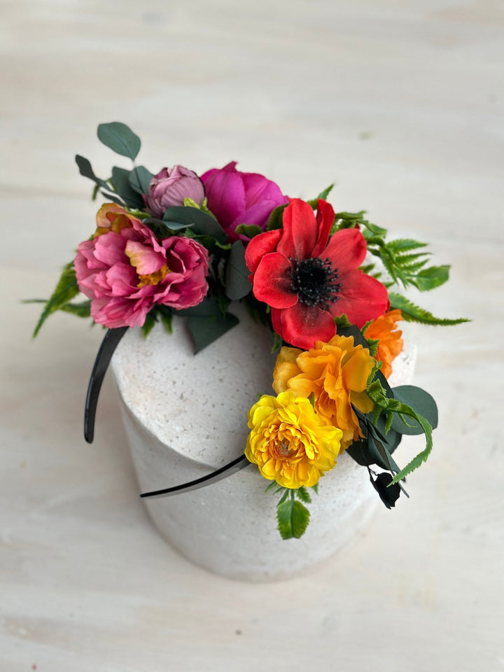 Floral headband with pink, red, and yellow flowers on a white background