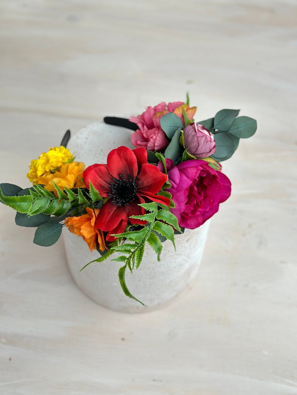 Floral headband with colorful flowers on a light wooden surface
