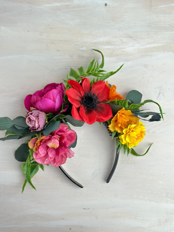 Floral headband with colorful flowers on a light wooden surface