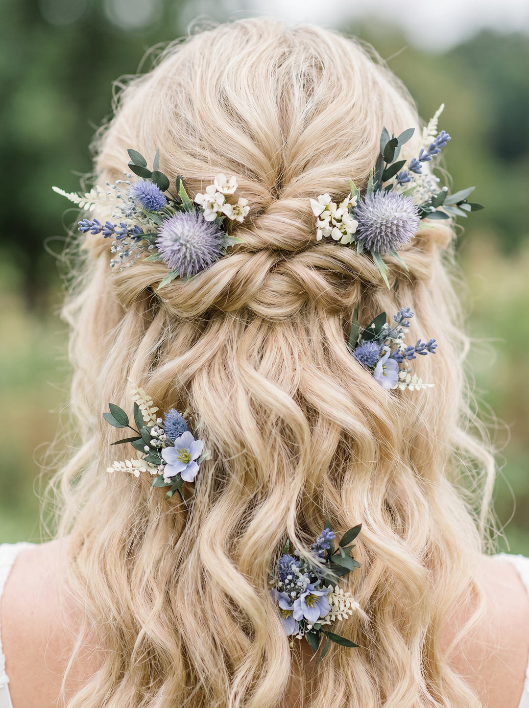 Blonde hair styled in a braid with floral decorations against a blurred natural background