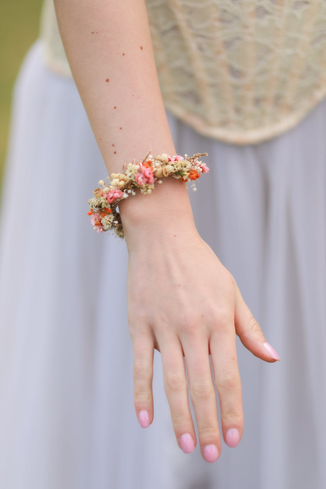 Hand wearing a colorful bracelet with a blurred background