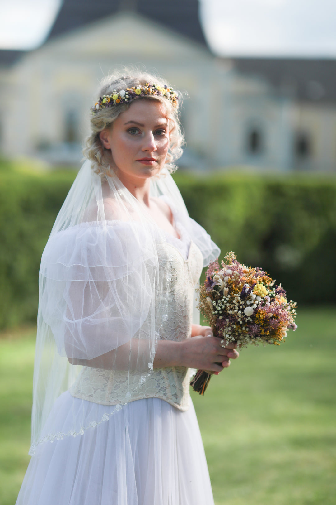 Bride holding a bouquet of flowers outdoors with a blurred background