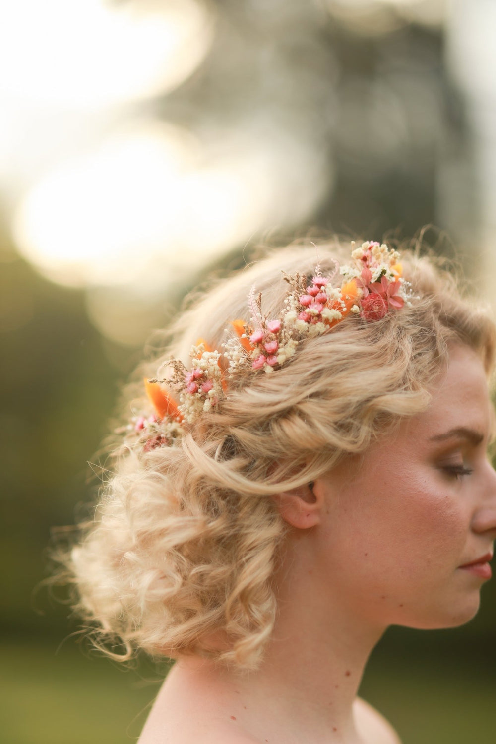 Woman with floral dried hairpins against a blurred natural background