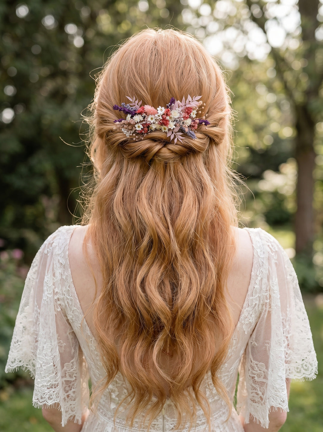Woman with long, wavy hair adorned with a floral hair comb from dried flowers in an outdoor setting.