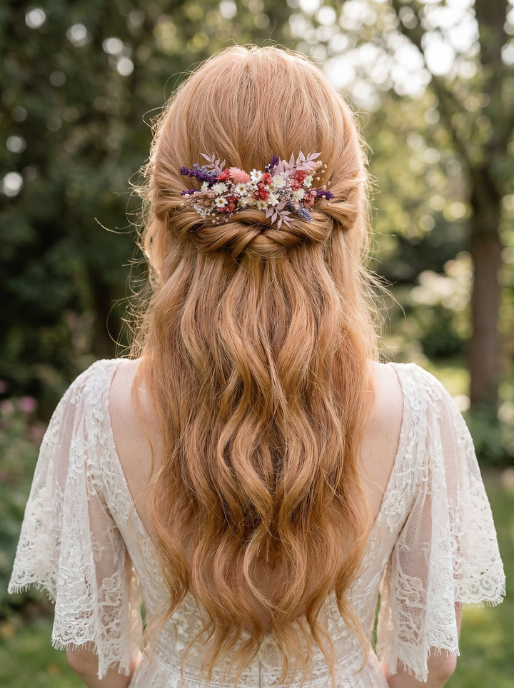 Woman with long, wavy hair adorned with a floral hair comb from dried flowers in an outdoor setting.