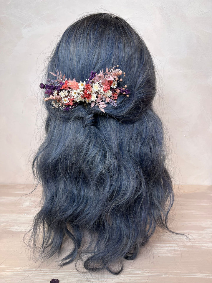 Blue hair with a floral hair accessory on a light background