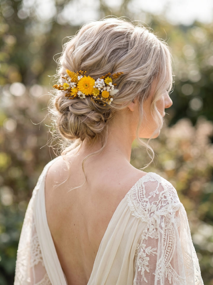 Woman with a floral hairpiece in her blonde hair, wearing a lace dress outdoors.