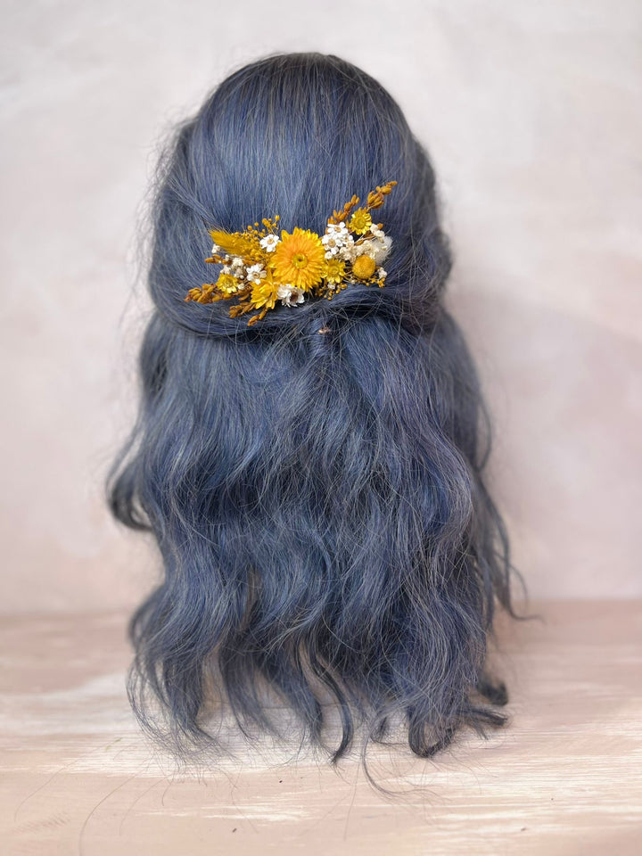 Blue hair with a floral hair yellow hair comb on a light background