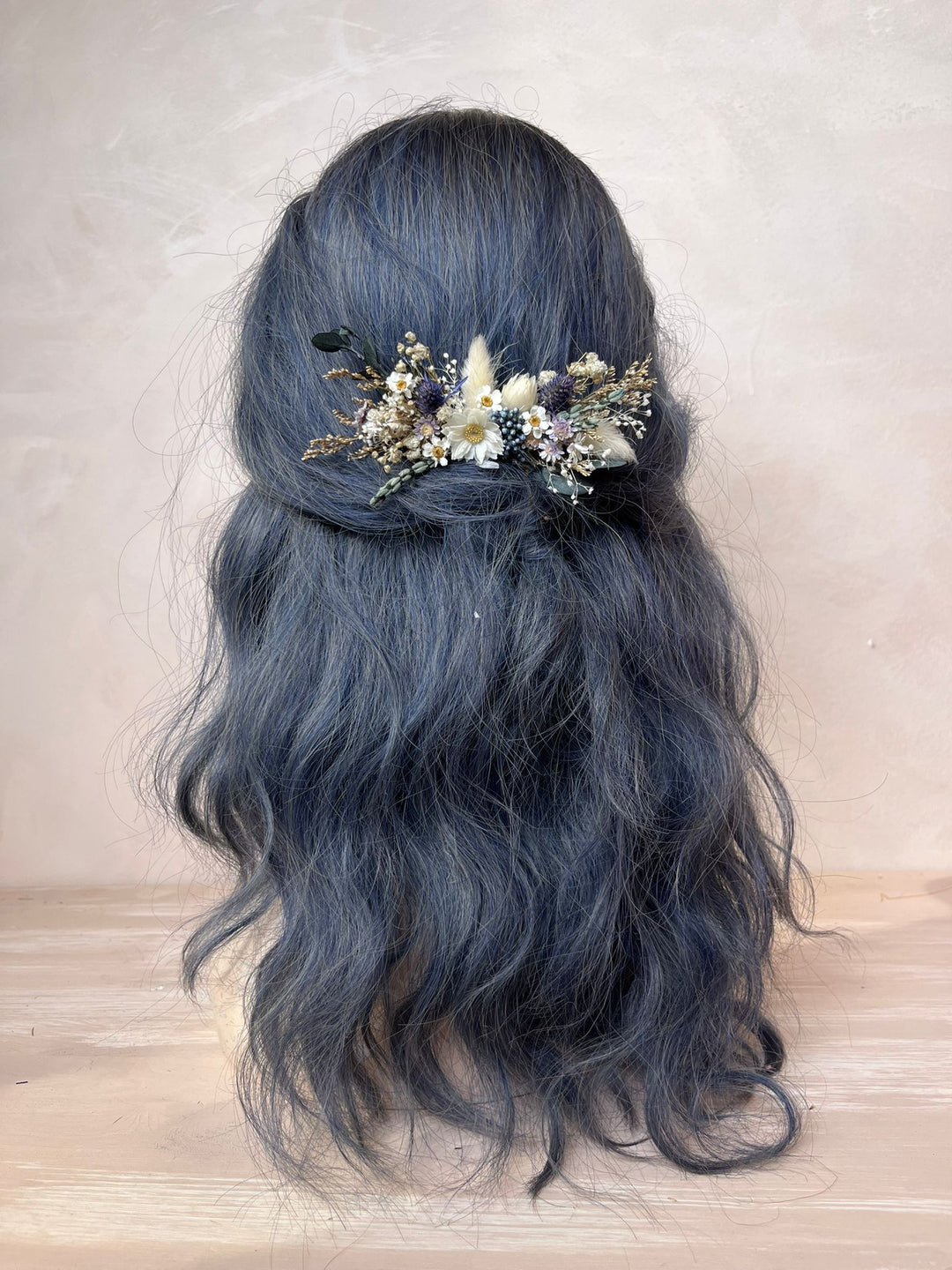 Blue hair with floral hair comb on a neutral background