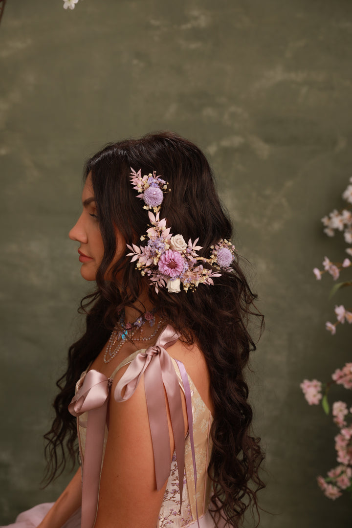 Woman with floral hairpiece and ribbons against a green background