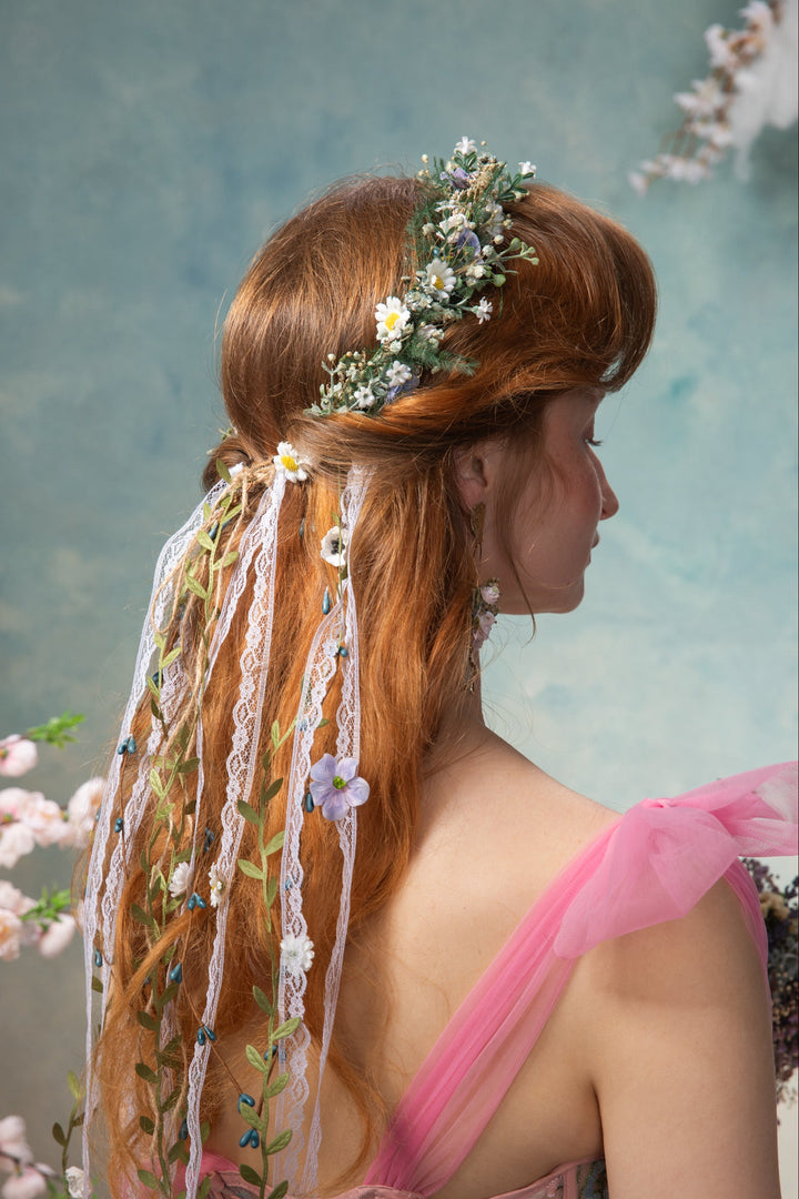 Woman with floral hairpiece and veil against a floral background