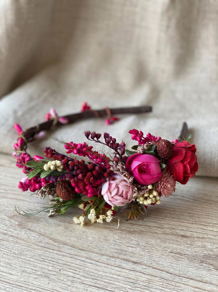Floral headband with pink and red flowers on a wooden surface