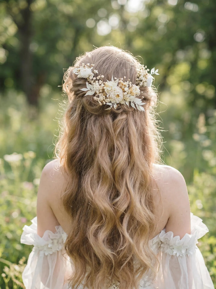 Woman with long, wavy hair wearing a floral headpiece in a natural setting.