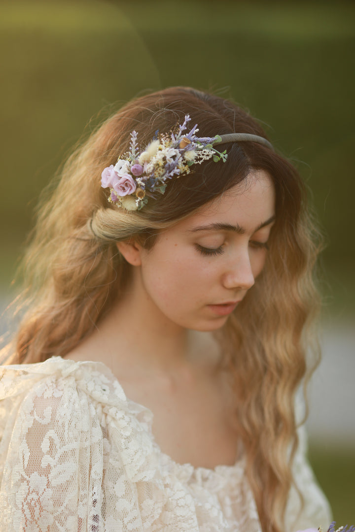 Woman wearing a floral headband with a blurred natural background