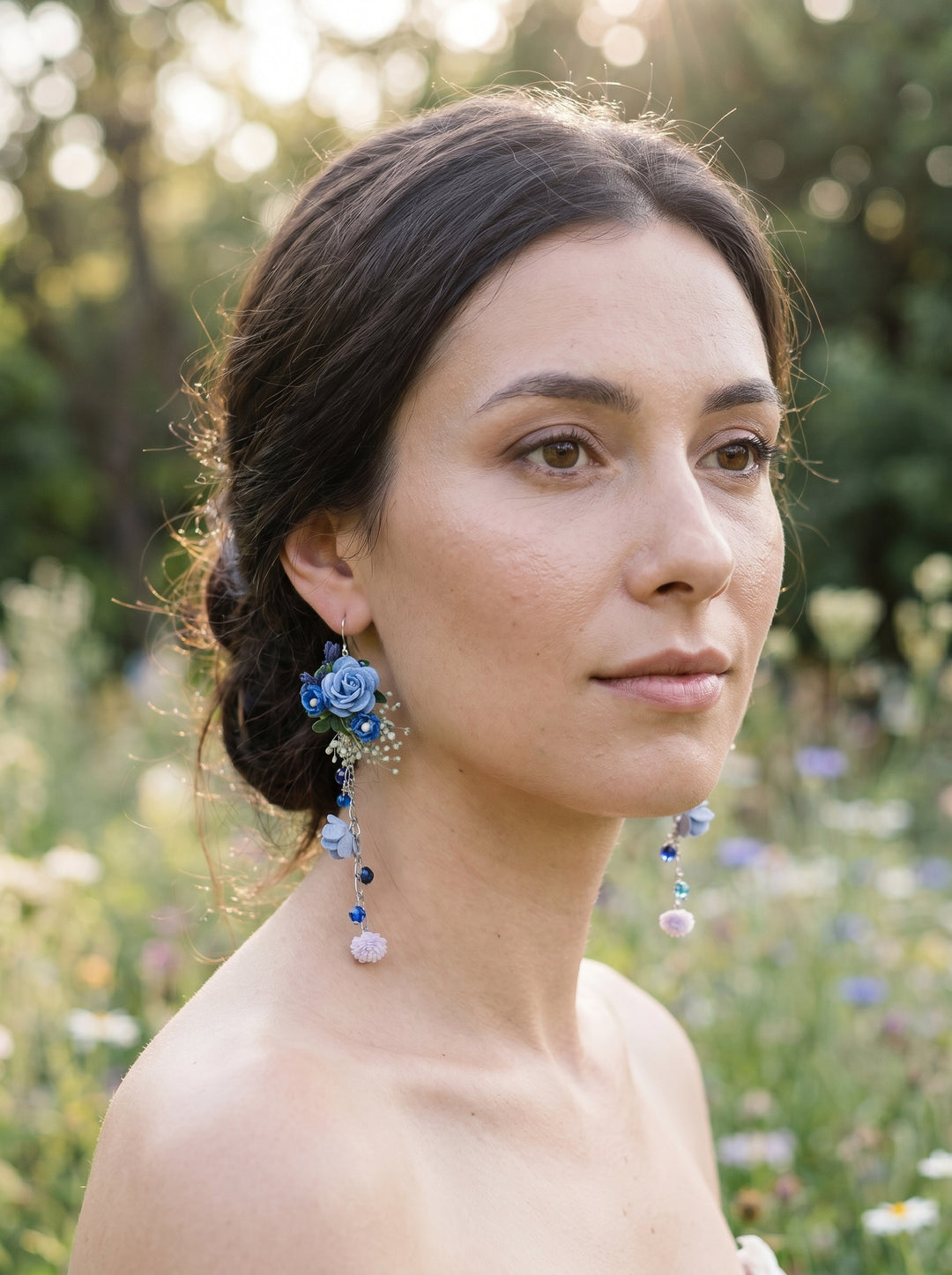 Woman with floral earrings with beads and blue roses in a natural setting
