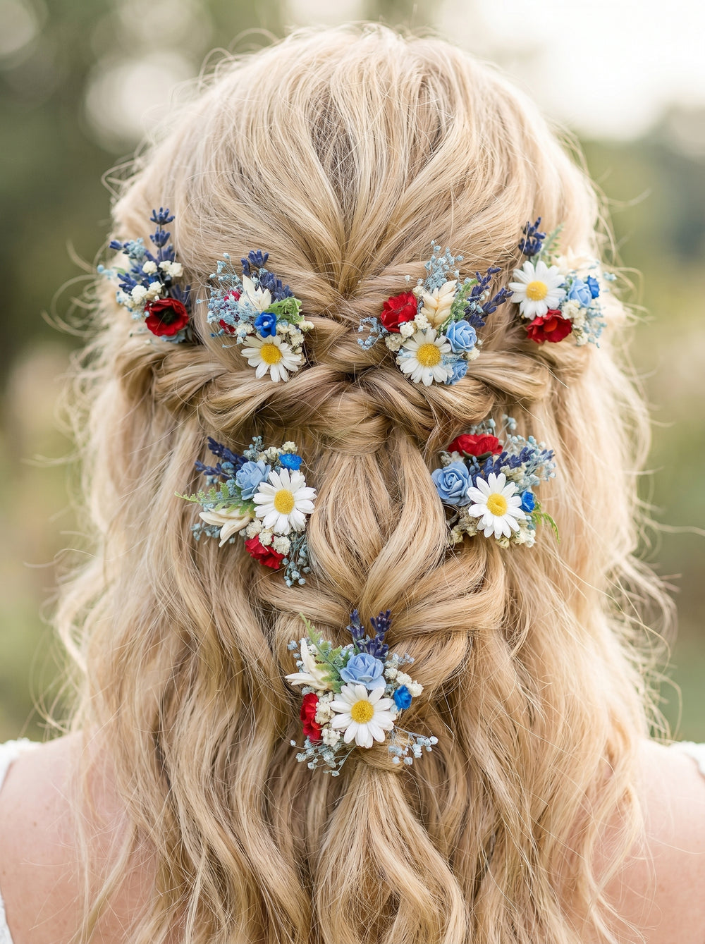 Blonde hair styled in braids with colorful flower hairpins against a blurred natural background