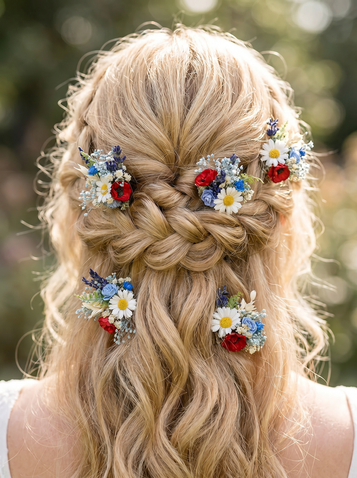 Blonde hair styled in a braid with floral wildflowers hairpins in folk style against a blurred natural background