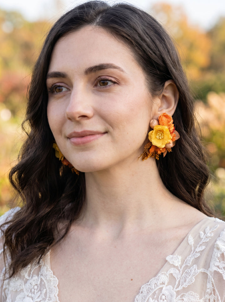 Woman wearing colorful floral earrings with a blurred natural background