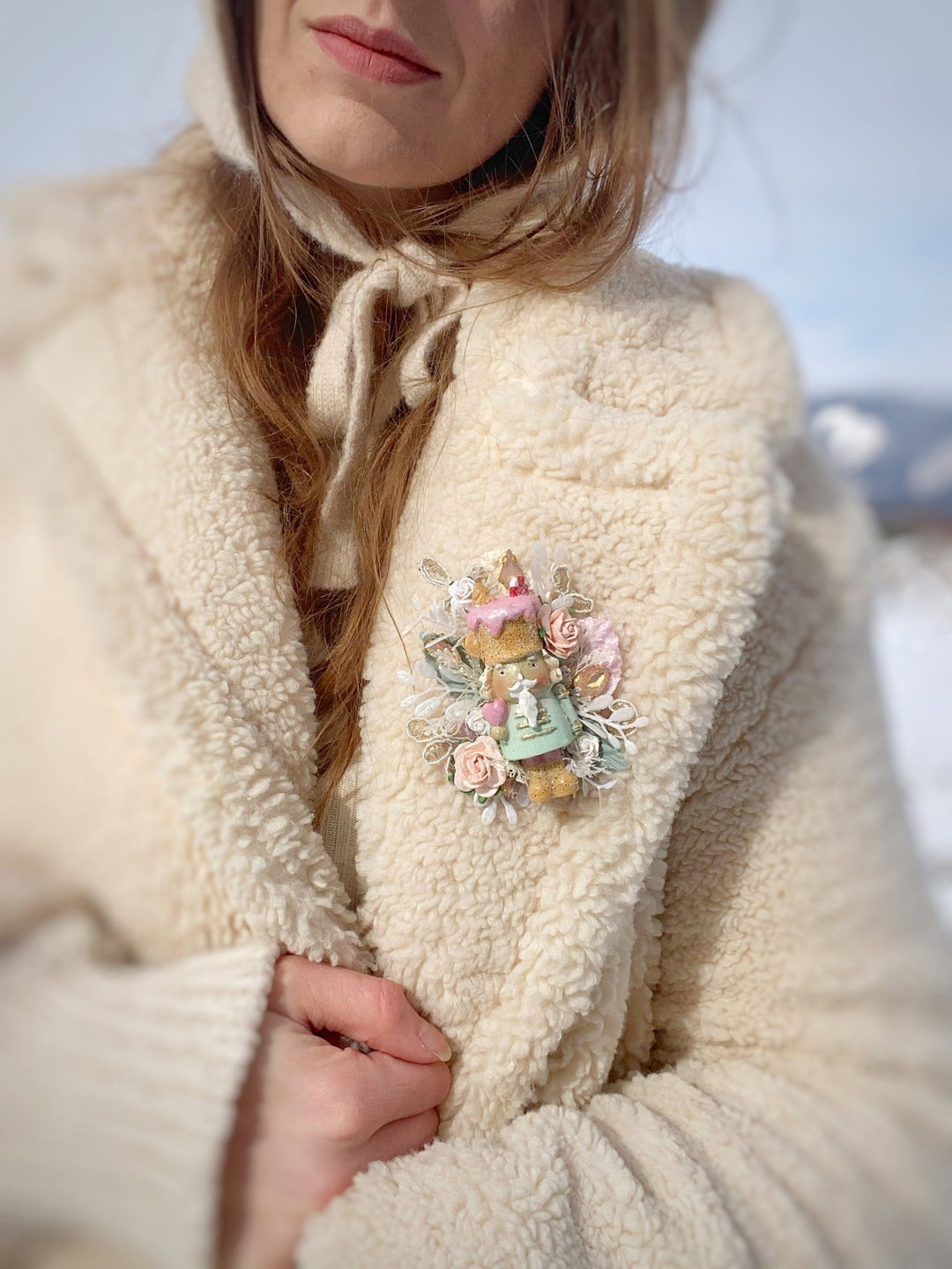 Woman in teddy coat with handmade chirstmas brooch in pastel tones 