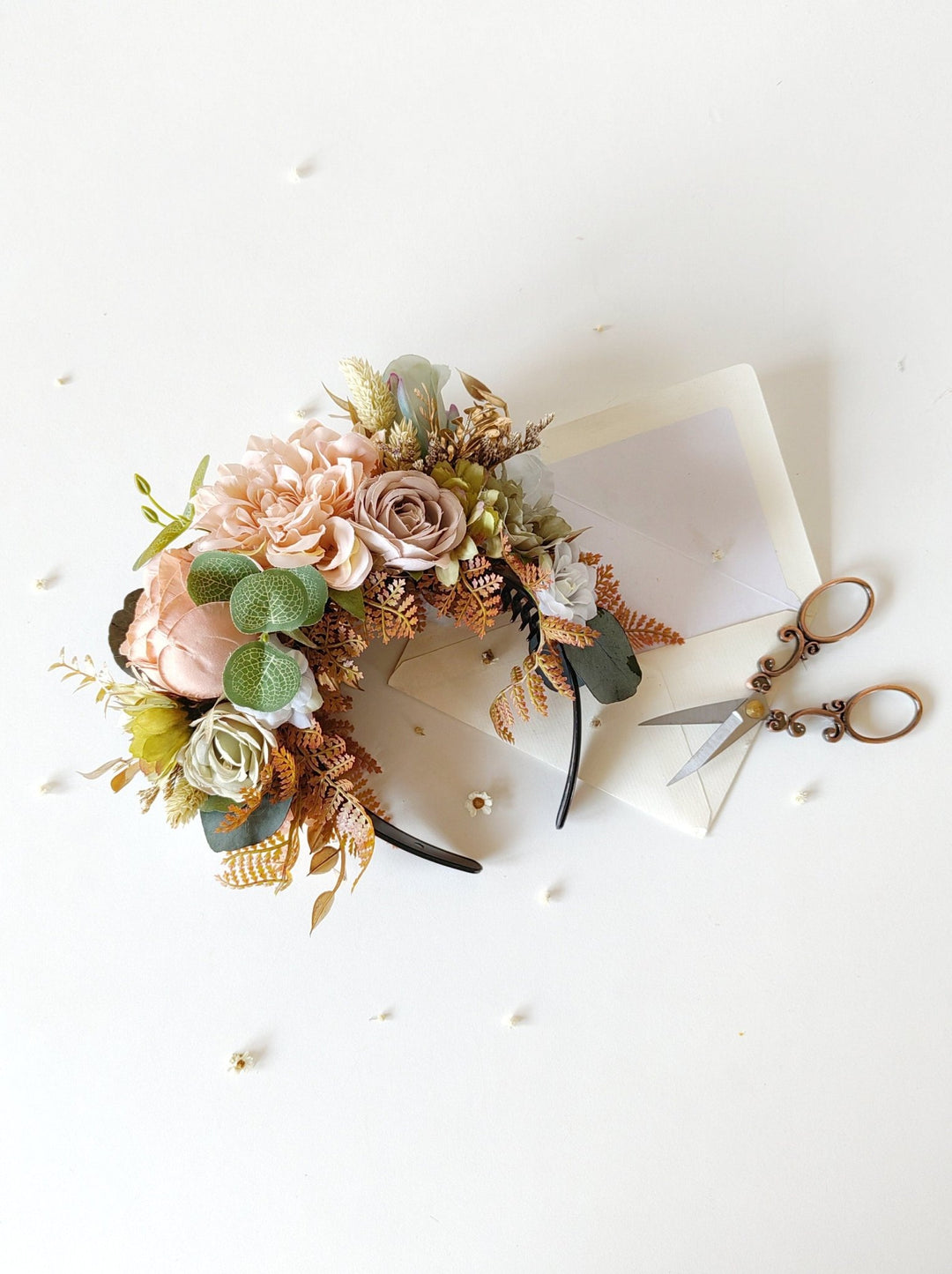 Floral headband with greenery on a white background with scissors.