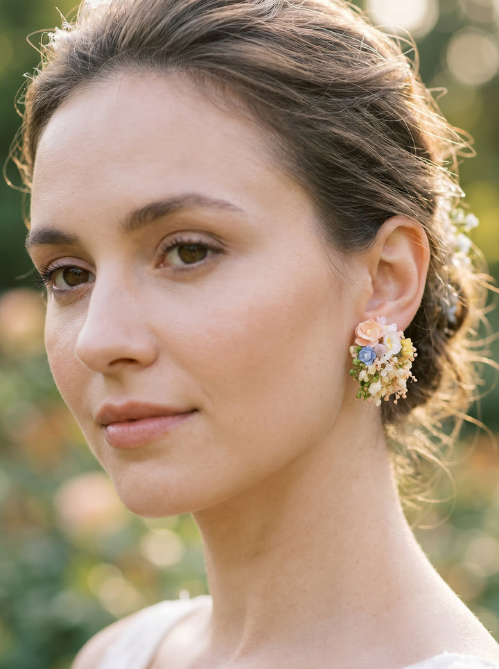Close-up of a woman wearing floral earrings with a blurred natural background