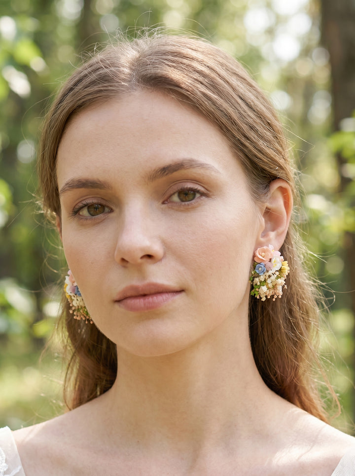 Woman wearing floral earrings with a blurred natural background