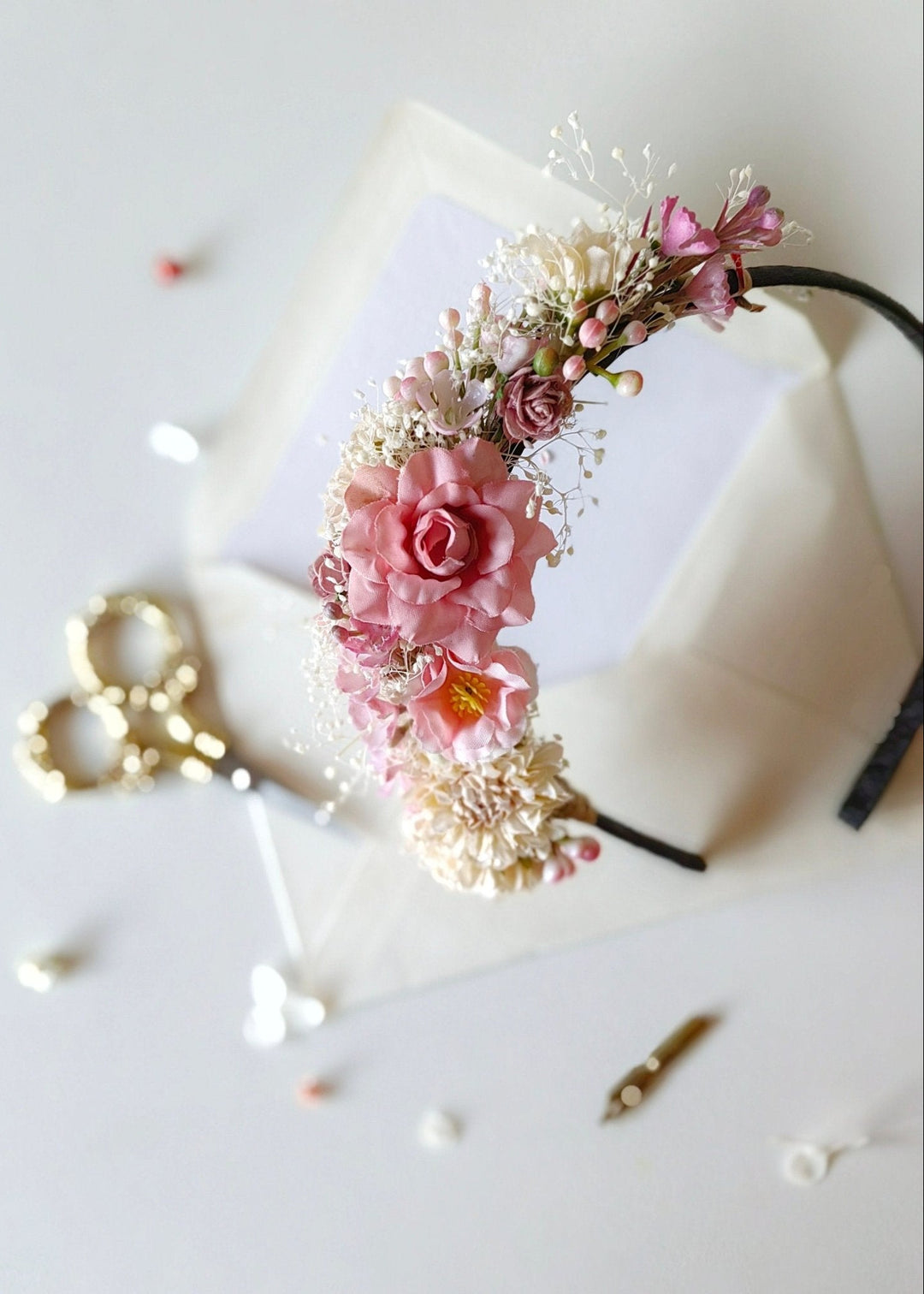 Floral headband with pink flowers on a white surface