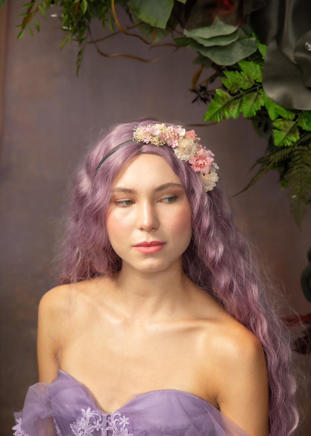 Woman with purple hair and floral headband against a floral backdrop