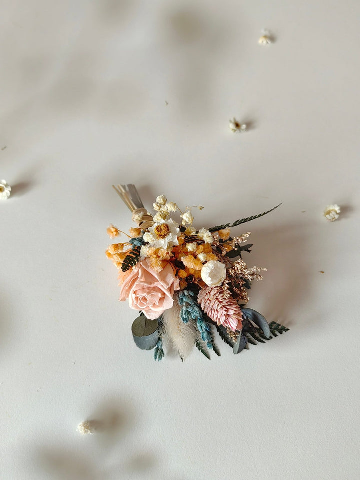 Floral arrangement with pink, blue and cream flowers on a light gray background