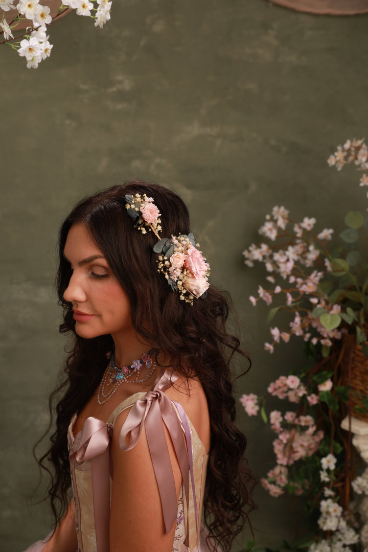 Woman with floral headpiece and ribbons against a green background